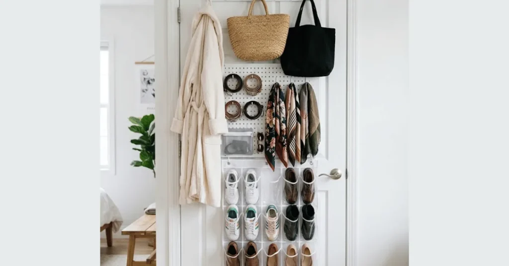 Over-door closet organizer system showing hook bar for bags, pegboard for accessories, and clear shoe pockets on closet door interior
